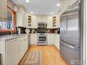 Modern kitchen featuring stainless steel appliances, granite countertops, wood floors, and bright recessed lighting for a sleek design at 810 Lotus Way, Broomfield, CO 80020