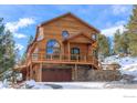 Charming wood home with a two-car garage and stone accents on a snow-covered lot at 84 Canon View Rd, Boulder, CO 80302