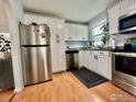 Bright kitchen with white cabinets, stainless steel appliances, granite countertops, and hardwood floors at 98 N 12Th Ave, Brighton, CO 80601