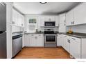 Well-lit kitchen features white cabinets, stainless steel appliances, and granite countertops at 98 N 12Th Ave, Brighton, CO 80601