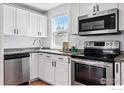 A modern kitchen is equipped with stainless steel appliances and granite countertops at 98 N 12Th Ave, Brighton, CO 80601