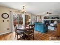 Bright and airy dining area adjacent to a cozy living room featuring a fireplace and hardwood floors at 14396 Corrine Ct, Broomfield, CO 80023