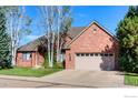 Charming brick home featuring a well-manicured lawn and a spacious two-car garage at 2425 Waneka Lake Trl, Lafayette, CO 80026