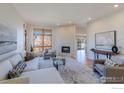 Spacious living room with large windows, fireplace, neutral paint, and cozy seating at 2425 Waneka Lake Trl, Lafayette, CO 80026