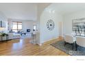 Spacious living room with hardwood floors, lots of light, a fireplace, and a dining area in the background at 2425 Waneka Lake Trl, Lafayette, CO 80026