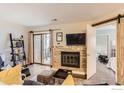 Cozy living room featuring a fireplace, barn door accent, and sliding door access to the outside at 2962 Shadow Creek Dr # 105, Boulder, CO 80303