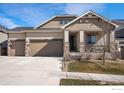 Charming home featuring a three-car garage, stone accents, neutral siding and covered porch, perfect for enjoying outdoor living at 12596 Eagle River Rd, Firestone, CO 80504