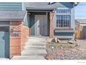 Inviting front entrance with brick accents and a well-manicured landscape at 1454 Alpine St, Longmont, CO 80504