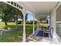 Inviting front porch with seating area, decorative rug, and lush green surroundings offering a peaceful outdoor space at 14798 N 115Th St, Longmont, CO 80504