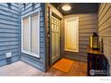 Charming front entrance with a wood porch and an exterior light fixture at 1534 Bradley Dr, Boulder, CO 80305