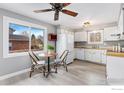 Modern kitchen with white cabinets, updated appliances, and a breakfast table with views of the outdoors at 159 Judson St, Longmont, CO 80501