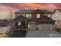 Charming two-story home featuring a covered front porch, stone accents, and a two-car garage at 15955 Humboldt Peak Dr, Broomfield, CO 80023