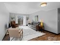 Bright living room featuring a comfortable sofa, armchairs, and natural light from the balcony doors at 1606 Cottonwood Dr # 24, Louisville, CO 80027