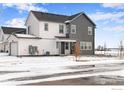 Modern two-story home with gray and white siding, a well-kept lawn, and wintery landscaping at 1784 Glacier Ave, Berthoud, CO 80513