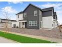 Charming modern two-story home with gray and white siding, a well-kept lawn and gravel landscaping at 1784 Glacier Ave, Berthoud, CO 80513