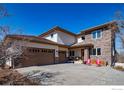 Charming home with stone accents, a three-car garage, and a cozy front porch area with seating at 2005 Calico Ct, Longmont, CO 80503