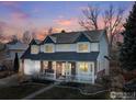 Beautiful two-story home with brick accents and a cozy front porch, set against a colorful dusk sky at 2111 Pintail Dr, Longmont, CO 80504