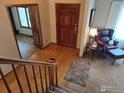 Welcoming foyer featuring hardwood floors, a wooden front door, and a cozy sitting area at 2525 22Nd Dr, Longmont, CO 80503