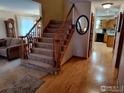 Inviting hallway with hardwood floors, staircase and views into the kitchen and living room at 2525 22Nd Dr, Longmont, CO 80503