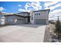 A modern two-story home is displayed with a three-car garage and concrete driveway at 3564 Doubletrack Ln, Castle Rock, CO 80108