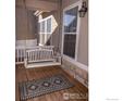 Relaxing porch swing enhances the charm of this inviting covered front porch with decorative rug at 4315 Bella Vista Dr, Longmont, CO 80503