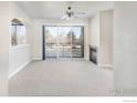 Bright living room with neutral carpet, fireplace, arched doorway, and sliding glass doors to balcony at 4500 Baseline Rd # 1208, Boulder, CO 80303