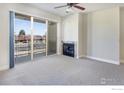 Comfortable living room featuring a fireplace, neutral carpet, ceiling fan and sliding glass doors to the balcony at 4500 Baseline Rd # 1208, Boulder, CO 80303