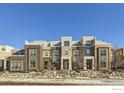 Attractive townhome featuring a combination of brick and gray siding, complemented by well-maintained landscaping at 5390 Valentia St, Denver, CO 80238