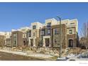 Modern townhouse exterior with brick and gray siding, large windows, and manicured landscaping at 5390 Valentia St, Denver, CO 80238