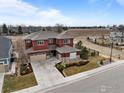 An aerial shot showcases the property's layout, landscaping, and proximity to open fields and other homes at 626 Trails At Coal Creek Dr, Lafayette, CO 80026