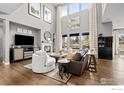 Open living room with hardwood floors, high ceilings, a fireplace, and abundant natural light from large windows at 626 Trails At Coal Creek Dr, Lafayette, CO 80026