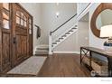 Inviting foyer features a wood door, hardwood floors, and staircase at 644 S Manorwood Ln, Louisville, CO 80027