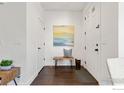 Bright entryway with white walls, hardwood floors, and a rustic wooden bench at 8146 E 53Rd Dr, Denver, CO 80238