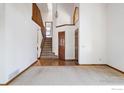 Bright foyer features a staircase, wood floors, and neutral carpet, leading to other areas of the house at 8239 Kincross Way, Boulder, CO 80301