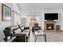 Comfortable living room featuring a fireplace, vaulted ceilings, and ample natural light at 862 S Reed Ct # D, Lakewood, CO 80226