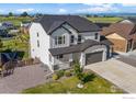 Back aerial view of a modern home with a well-kept yard and a mountain view in the distance at 1013 Gabriella Ln, Berthoud, CO 80513