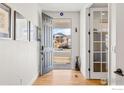 Bright entryway featuring hardwood floors, white walls, and a modern front door at 1013 Gabriella Ln, Berthoud, CO 80513