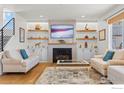 Inviting living room with a fireplace, built-in shelves, and hardwood floors at 1013 Gabriella Ln, Berthoud, CO 80513