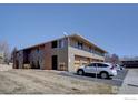 Well-maintained exterior of a condo building with parking spaces and mature landscaping at 1105 Bacchus Dr # 8, Lafayette, CO 80026