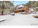 Exterior view of dome home with snow-covered deck and staircase at 11186 Circle Dr, Golden, CO 80403