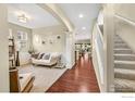 Comfortable living room with hardwood floors, plush carpeting, and a staircase at 12214 Roslyn St, Thornton, CO 80602