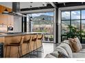 Modern kitchen featuring bar seating, stainless steel hood, and mountain views at 1360 Walnut St # Ph 401, Boulder, CO 80302