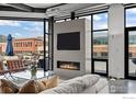 Bright living room with gas fireplace, TV, and mountain views through large windows at 1360 Walnut St # Ph 401, Boulder, CO 80302