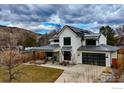 Daytime view of modern farmhouse with solar panels, large garage and inviting front porch at 1415 Riverside Ave, Boulder, CO 80304