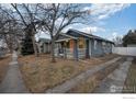 Charming blue single-story home with a well-maintained yard and an asphalt driveway at 1560 Clinton St, Aurora, CO 80010