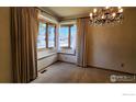 Bright dining room with large windows, a window seat, and elegant chandelier at 2136 Westlake Dr, Longmont, CO 80503