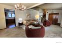 Cozy living room featuring neutral carpeting, a chandelier, and comfortable seating at 2136 Westlake Dr, Longmont, CO 80503