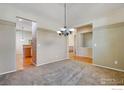 Open dining area with neutral walls, chandelier, and hardwood floors at 2443 Winding Dr, Longmont, CO 80504