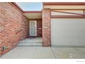 Close up of the front exterior with brick facade and covered entry at 2604 Elmhurst Cir, Longmont, CO 80503