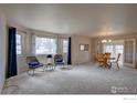 Spacious living room featuring bay windows and adjoining dining area at 2604 Elmhurst Cir, Longmont, CO 80503